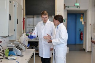 An image of Prof. Kath-Schorr in the chemistry lab, providing an introduction to a lab equipment to a member of her research group.